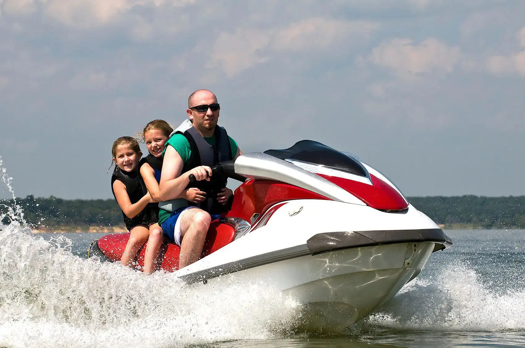 A man and two children on a jet ski.