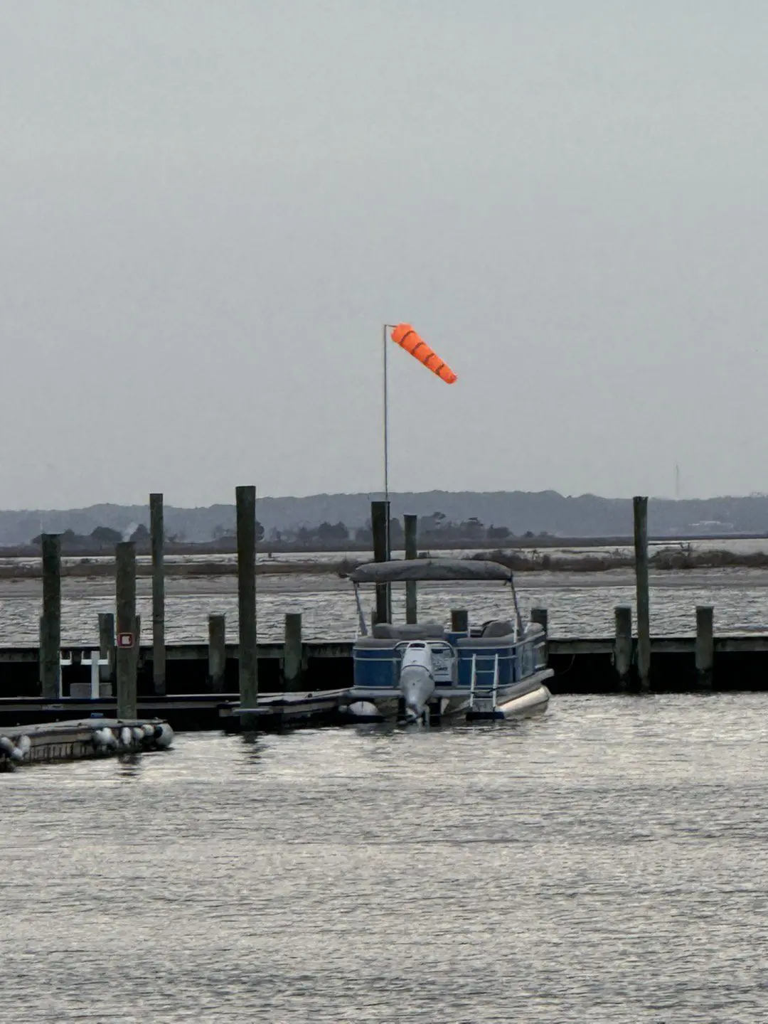 A boat is docked in the water near some piers.