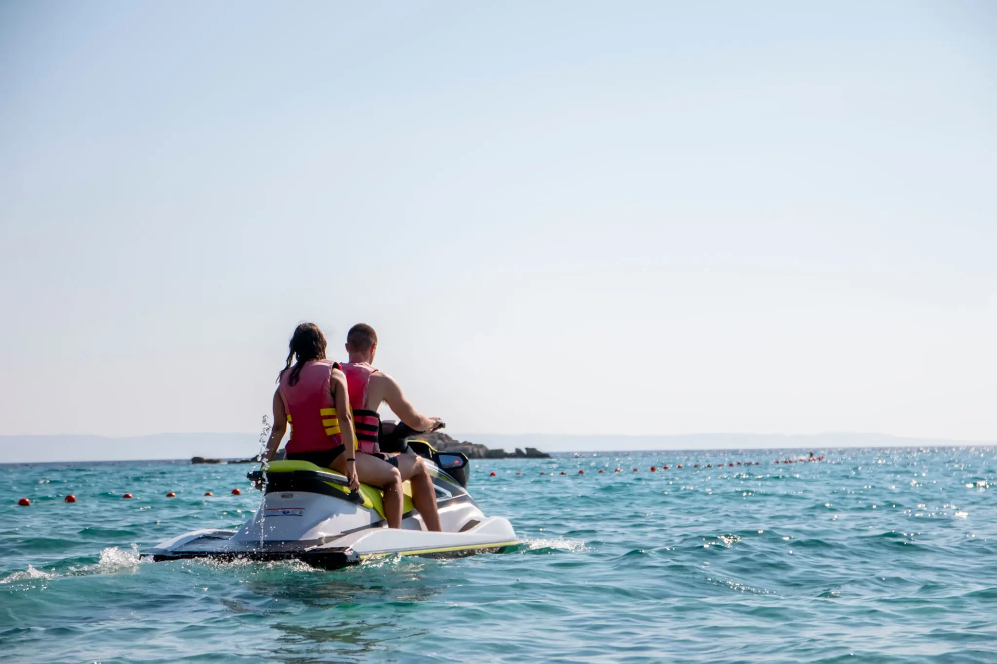 A couple of people on jet skis in the ocean.