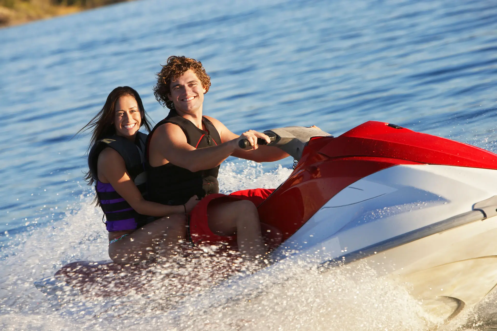 Two women are riding a water ski in the ocean.
