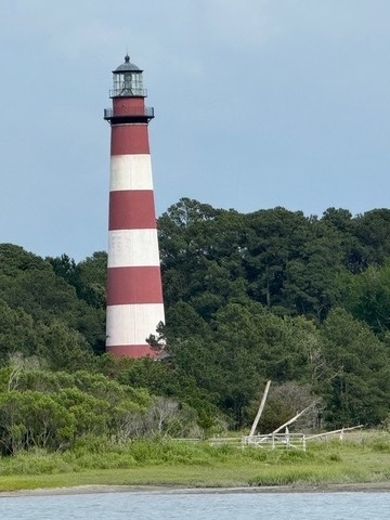 small tower near a body of water with Assateague Island in the background