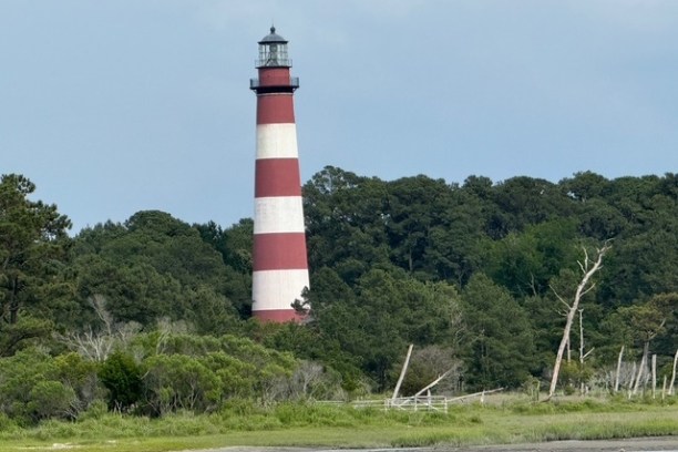 small tower near a body of water with Assateague Island in the background