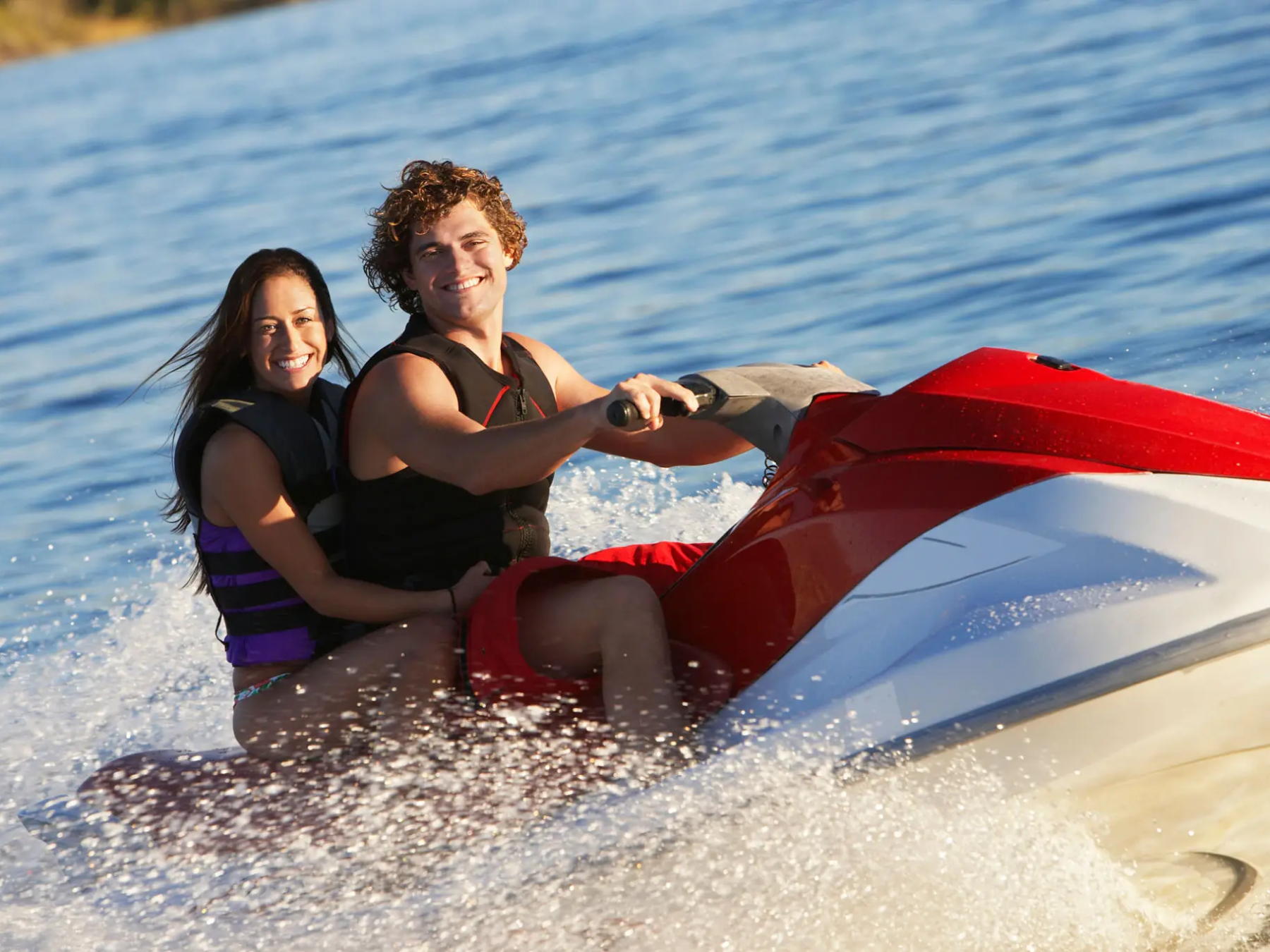 a woman sitting next to a body of water